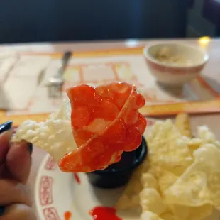 ows a hand holding a piece of food