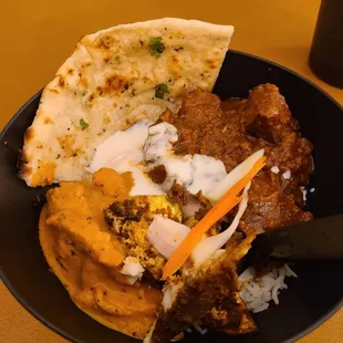 Butter chicken, garlic naan, goat tika masala, raita, and basmati rice