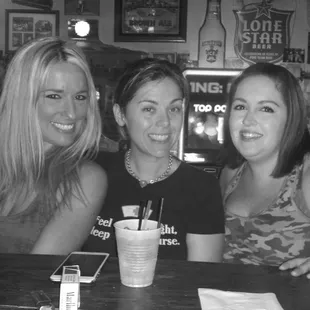 three women sitting at a bar