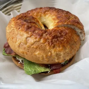 a bagel sandwich with bacon and lettuce