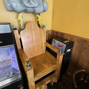 a wooden chair in front of a refrigerator