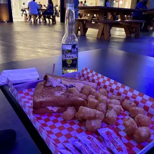 a tray of doughnuts and a bottle of beer