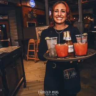 a woman holding a tray of drinks