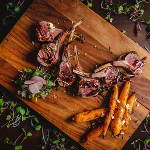 lamb chopping on a cutting board with carrots and radishes