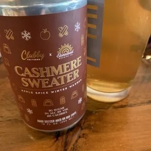 a can of cashmere sweater next to a glass of beer
