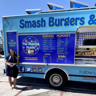a woman standing in front of a food truck