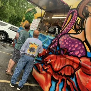 a man standing in front of a food truck