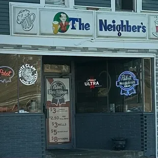 The big sign reads The Neighber's which doesn't make sense and the neon sign reads Pabst Neighbors Beer.