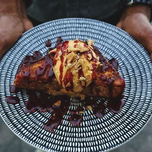 Custard french toast with pumpkin cream spread, cranberry vanilla bourbon sauce topped with crumbled graham cracker