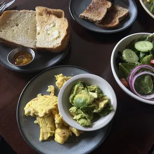 a breakfast of eggs, bread, and salad