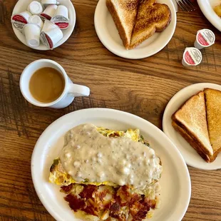 a breakfast of eggs, bacon, toast, and gravy