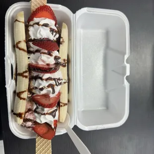 a banana split in a styrofoam container