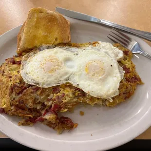 Corned Beef Hash with hash browns and eggs slightly runny.