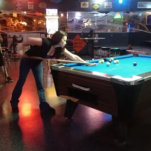 a woman playing a game of pool