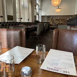 a table with a menu and glasses on it