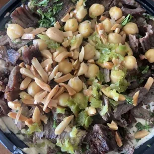 a bowl of salad with beef, broccoli and cashews