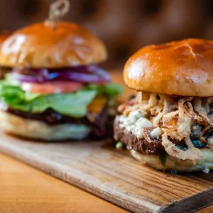 two burgers on a wooden board