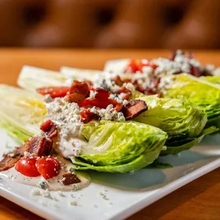a plate of lettuce with bacon and tomatoes