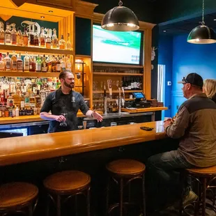 a bar with people sitting at the bar