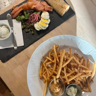 a plate of french fries and a plate of salmon