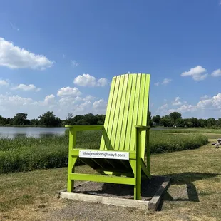 a bright green chair in front of a lake