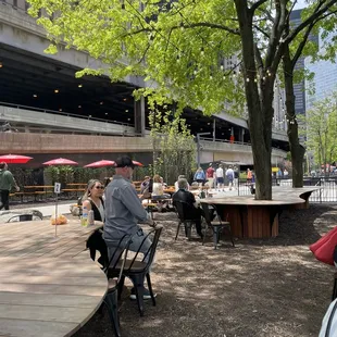 people sitting at tables with umbrellas