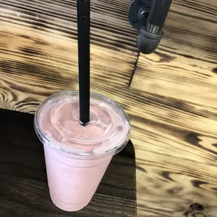 a smoothie in a plastic cup with a straw
