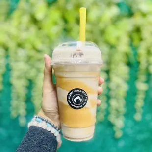 a hand holding a cup of iced coffee