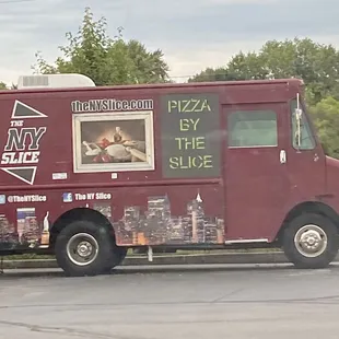 a red food truck parked on the side of the road