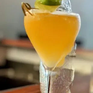 a cocktail in a glass with a garnish