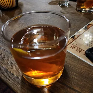 a glass of whiskey on a wooden table