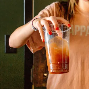 a woman holding a glass of orange juice