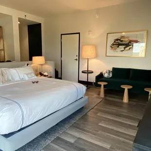 The king bed, luscious teal velvet sofa and mini bar area behind the bed.