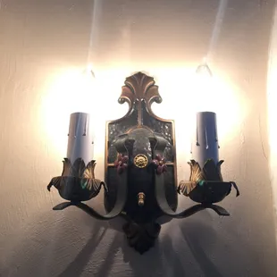 a wall sconce with two candles