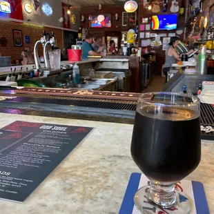 a glass of beer on a bar