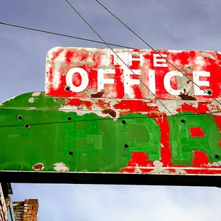 an old neon sign on the side of a building