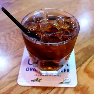 a glass of iced tea on a coaster