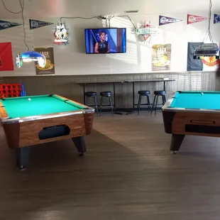 two pool tables and a television