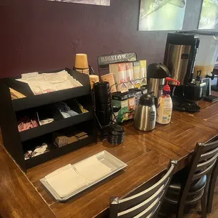 a table with a coffee maker and a menu on it