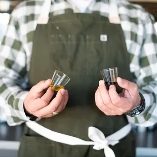 a man holding two shot glasses