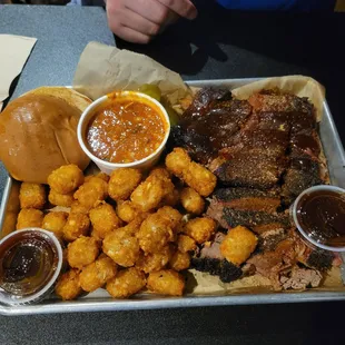 Combo platter with brisket and sliced pork and Brunswick stewand tater tots