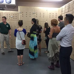 a group of people standing in front of wooden lockers