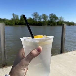 a hand holding a plastic cup with a drink in it