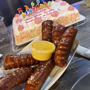 a plate of pretzels and a birthday cake