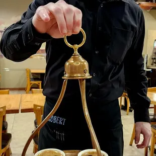 a man holding a tray with two cups of coffee