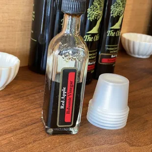 a bottle of olive oil and cups