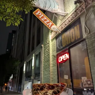 a slice of pizza on a paper plate