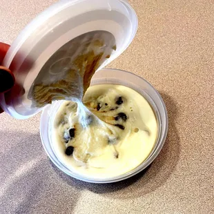 a hand holding a container of yogurt