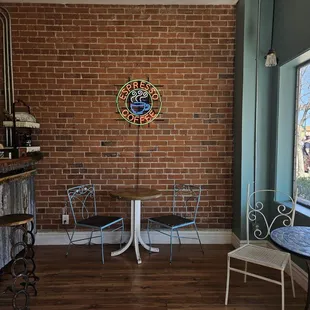 a table and chairs in front of a brick wall