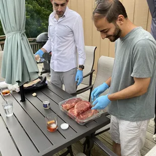two men preparing meat